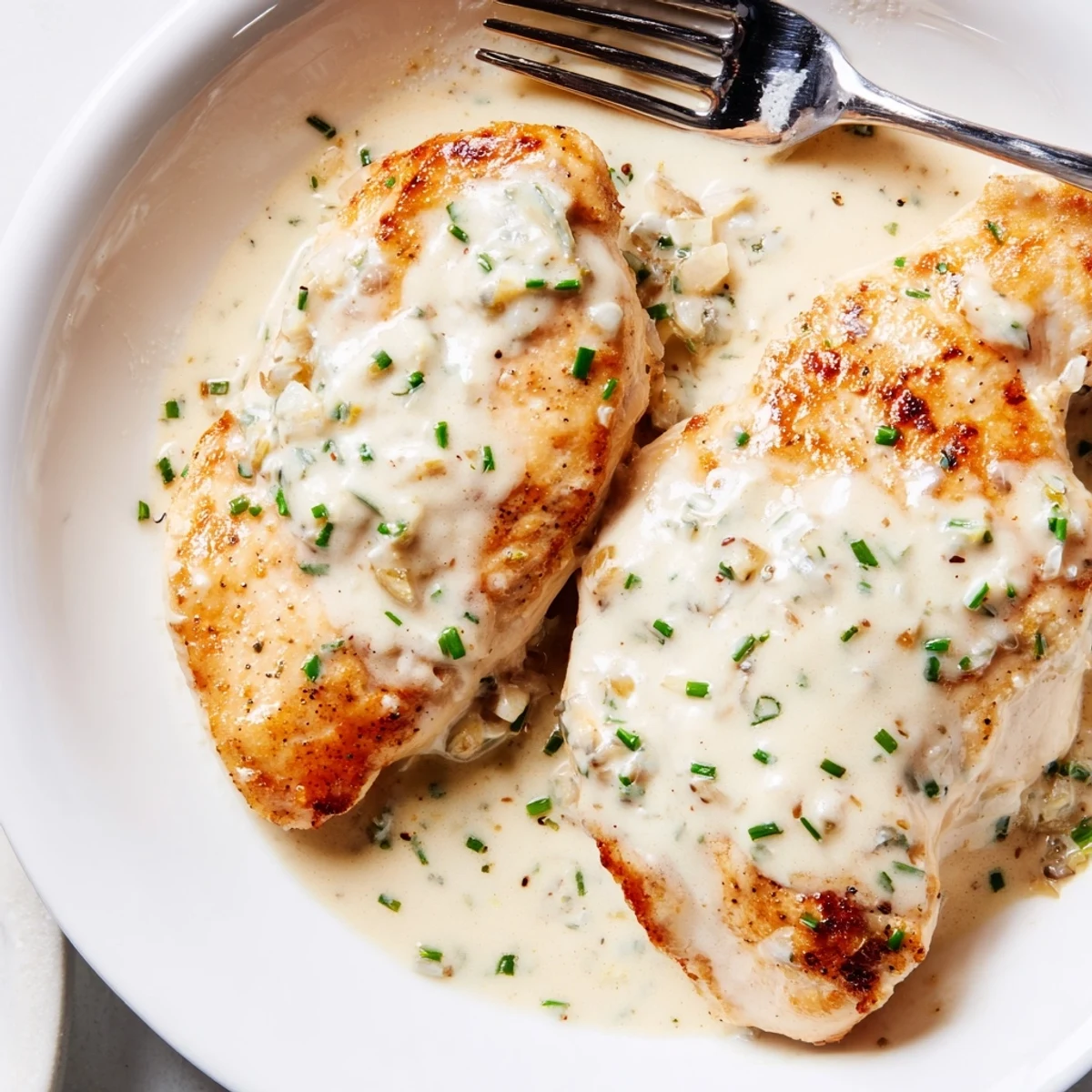 Golden seared cream cheese chicken nestled in a rich Parmesan cream sauce