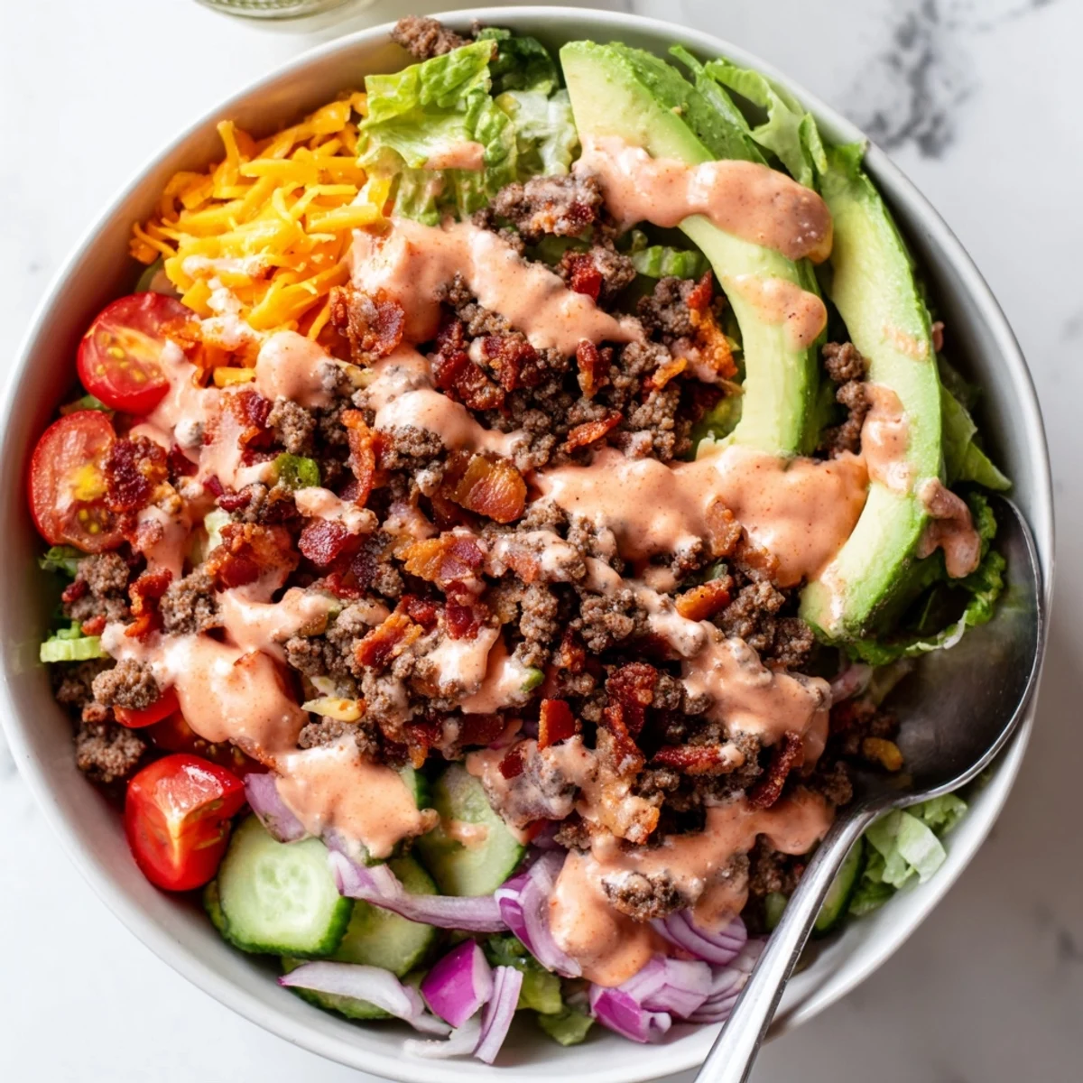 Warm savory beef and colorful veggies drizzled with sauce in burger bowls