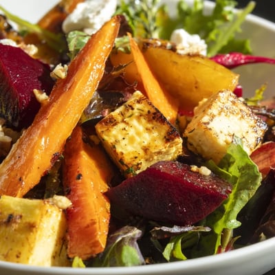 Colorful roasted roots glisten on greens in this Roasted Root Vegetable Salad, drizzled with a tangy balsamic vinaigrette for a bright finish.