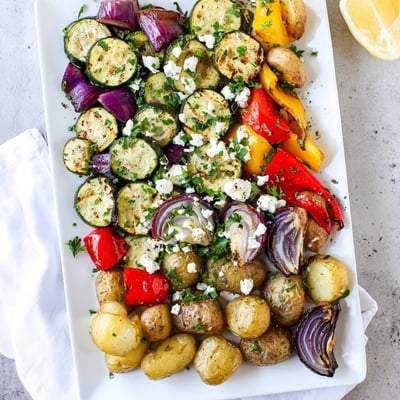One Pan Greek Vegetables roasted to perfection with colorful zucchini, peppers, and potatoes, ready to serve over quinoa.