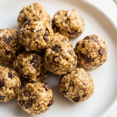 Cool mint energy balls in close-up, showing a chewy interior studded with mini chocolate chips on a marble counter.  