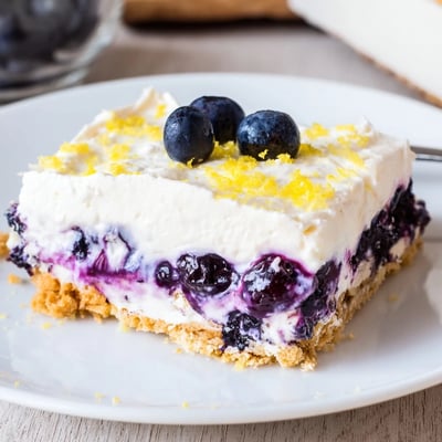 Sliced Lemon Blueberry Lasagna Recipe with buttery cookie crust and fluffy whipped topping